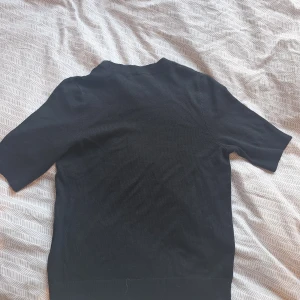 Stickad T-shirt - Svart stickad T-shirt från Lager 157. I storlek XS. Använd fåtal gånger inga defekter alls ser ut som ny. Pris kan diskuteras 