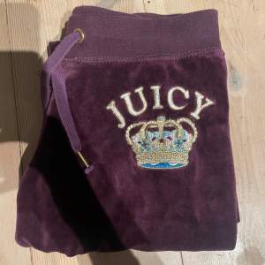 Säljer ett par supermysiga lila mjukisbyxor från Juicy Couture. De är i en härlig sammet och har en snygg broderad krona med texten 'JUICY' i guld och blått på ena benet. Byxorna är äkta vintage från 05. Midjemått ca 39 cm. Priset är diskuterbart! ❤️