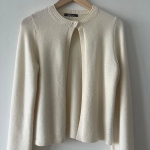 Trendig kofta från Gina Tricot  - Superfin vit/beige/creme trendig tunnstickad kofta med en knapp från gina tricot. Knappt använd. Den har inga skador. Helt slutsåld.