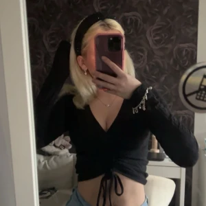 svart tröja med snören - du kan justera själv hur du vill ha tröjan med smörerna! har ett litet hål skriv för bild 🤍