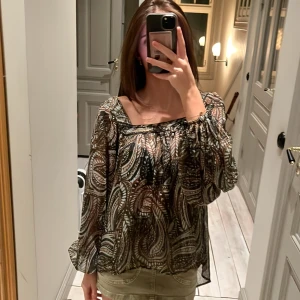 Mönstrad blus med fyrkantig halsringning  - Säljer en superfin blus med jättefint möster och fyrkantig halsringning!Blusen har långa ärmar och en luftig passform, perfekt för både vardag och fest. Materialet är lätt och bekvämt. Passar perfekt med jeans eller kjol! Köpt från Sellpy men tyckte den var lite för stor, så har inte använt den och prislappen därifrån är kvar!