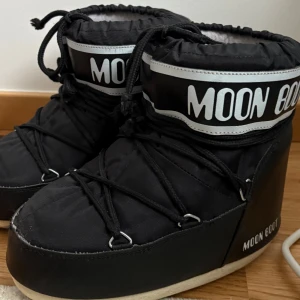 Moon Boot i klassiskt svart - Moon Boot i klassiskt svart – perfekt för vintersäsongen! De är i fint skick och har bara några små ytliga märken framtill som knappt syns.