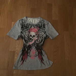 Grå t-shirt från temu - Grå t-shirt med stort tryck. Köpt från Temu. Knappt andvänd eftersom den sitter konstigt på mig.🥰 Inga skador eller nåt för ja har typ ba provat den en gång. Kp om frågor eller fler bilder.