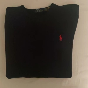 Marin blå tröja från Polo Ralph Lauren - Säljer en klassisk marin blå tröja från Polo Ralph Lauren i storlek s (Herrstorlek). Den har en röd broderad logga på bröstet och är perfekt för både vardag och fest. Tröjan är använd ett fåtal gånger.Tröjan är i mycket bra skick och passar till alla säsonger. Skön och stilren design! Pris går att diskutera.