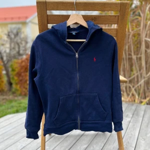 Ralph lauren zip hoodie mörkblå - Säljer en skön och fin mörkblå hoodie från ralph lauren i nästan nyskick. Storlek 14-16. Kom med bud!!  - svarar snabbt - skickar snabbt