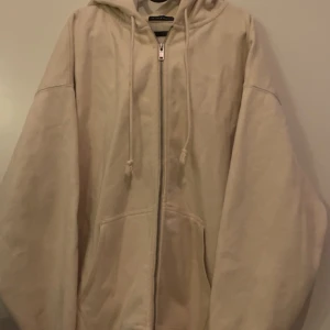Beige hoodie från Brandy Melville - Säljer en supermjuk och bekväm beige hoodie från Brandy Melville. Den har en dragkedja framtill och en stor luva. Det är en onesize men skulle personligen säga att den är som en L eller XL för mig som är S så ganska oversized och skönt material🥰🥰
