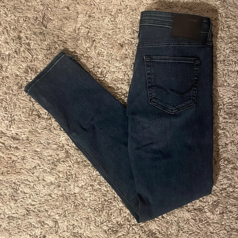 Säljer ett par snygga mörkblå jeans från Jack & Jones i modellen Slim/Glenn. De har en slim passform och är perfekta för både vardag och fest. Jeansen är i väldigt bra skick. Perfekta för höst och vår!. Jeans & Byxor.