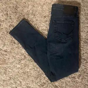 Säljer ett par snygga mörkblå jeans från Jack & Jones i modellen Slim/Glenn. De har en slim passform och är perfekta för både vardag och fest. Jeansen är i väldigt bra skick. Perfekta för höst och vår!