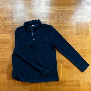 Mörkblå tröja från East West - Säljer en stilren mörkblå tröja från East West. Materialet är frotté. Tröjan är knappt använd och redo för en ny ägare! 