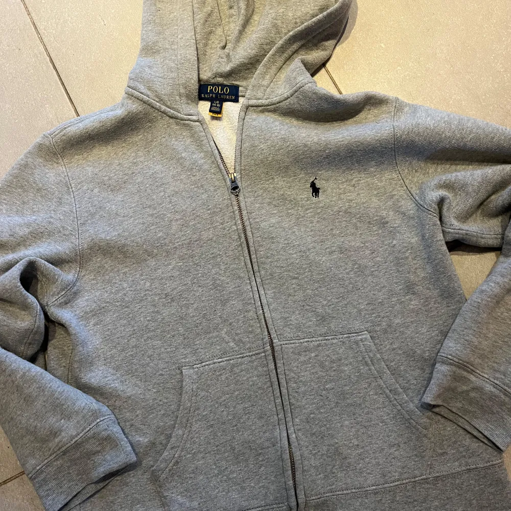 Grå Ralph Lauren hoodie med dragkedja. Strl junior large (14-16) men liten i strl så lagom till någon som är runt 155-160 cm skulle jag säga. Bra skick men använd. . Hoodies.