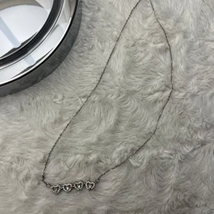 Silverhalsband med hjärtan och blommotiv - Ett elegant silverhalsband. Det ena alternativet  har fem glittriga hjärtan i rad, perfekt för en romantisk look. Det andra har ett vackert blomformat hänge med gnistrande detaljer. Halsbandet är tunt och stilrent, idealiska för både vardag och fest. 💖✨ halsbandet är aldrig använt. 