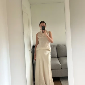 Ärmlös polotopp  - Superfin elegant topp med polokrage, perfekt till en långkjol eller kostymbyxor. Toppen är ärmlös och färgen kan beskrivas som ljus beige/rosa