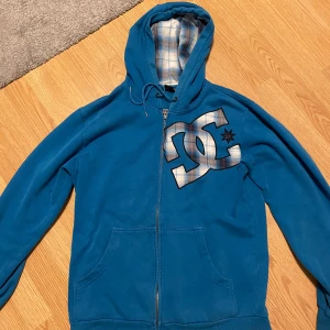 DC zip up - Fett DC zip up. Har några skador vid slutet av ärmarna och kanten av luvan men annars bra skick
