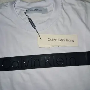 Säljer en snygg vit t-shirt från Calvin Klein. Oanvänd och ny. Storleken står S men den passar också M. Priset är ej hugget I sten!