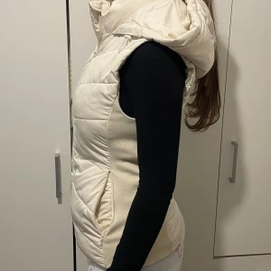 Krämvit/Beige Zara väst - Säljer min Krämvita/beiga väst från Zara som är slutsåld. Den är endast använd ett fåtal gånger och är därför i gott skick. Den är i storlek XS.