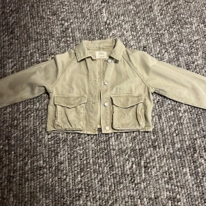 Beige jacka från Zara - Säljer en snygg beige jacka från Zara i storlek 11-12 år. Jackan har en croppad stil med knappar framtill och två praktiska fickor. Perfekt för vår och höst! 🧥