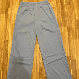 Blåa byxor - Blåa kostymbyxor i storlek L från Shein. De har en klassisk design med hög midja och raka ben. Helt oanvända! 