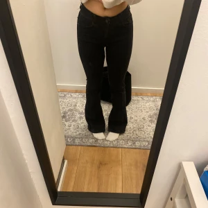 Svarta bootcut jeans - Säljer ett par svarta bootcut jeans i mycket bra skick. De är  och har en snygg passform som framhäver figuren. Perfekta för både vardag och fest! 