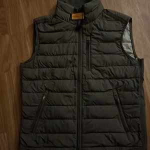 Svart dunväst från Parajumpers - Hej😄Jag säljer en svart/mörk grön parajumper väst i fint skick jag har inte kunnat använda den så mycket då den blev för liten för mig och den är bara använd några få tillfällen. Den har inga skador eller liknande. Mvh Anton😄