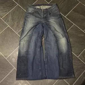 Handgjorda baggy flared jeans med små distress detaljer och en sjukt nice wash. Storlek 33/32 eller 44cm i midjan, 107cm långa och 37,5cm i benöppningen. 