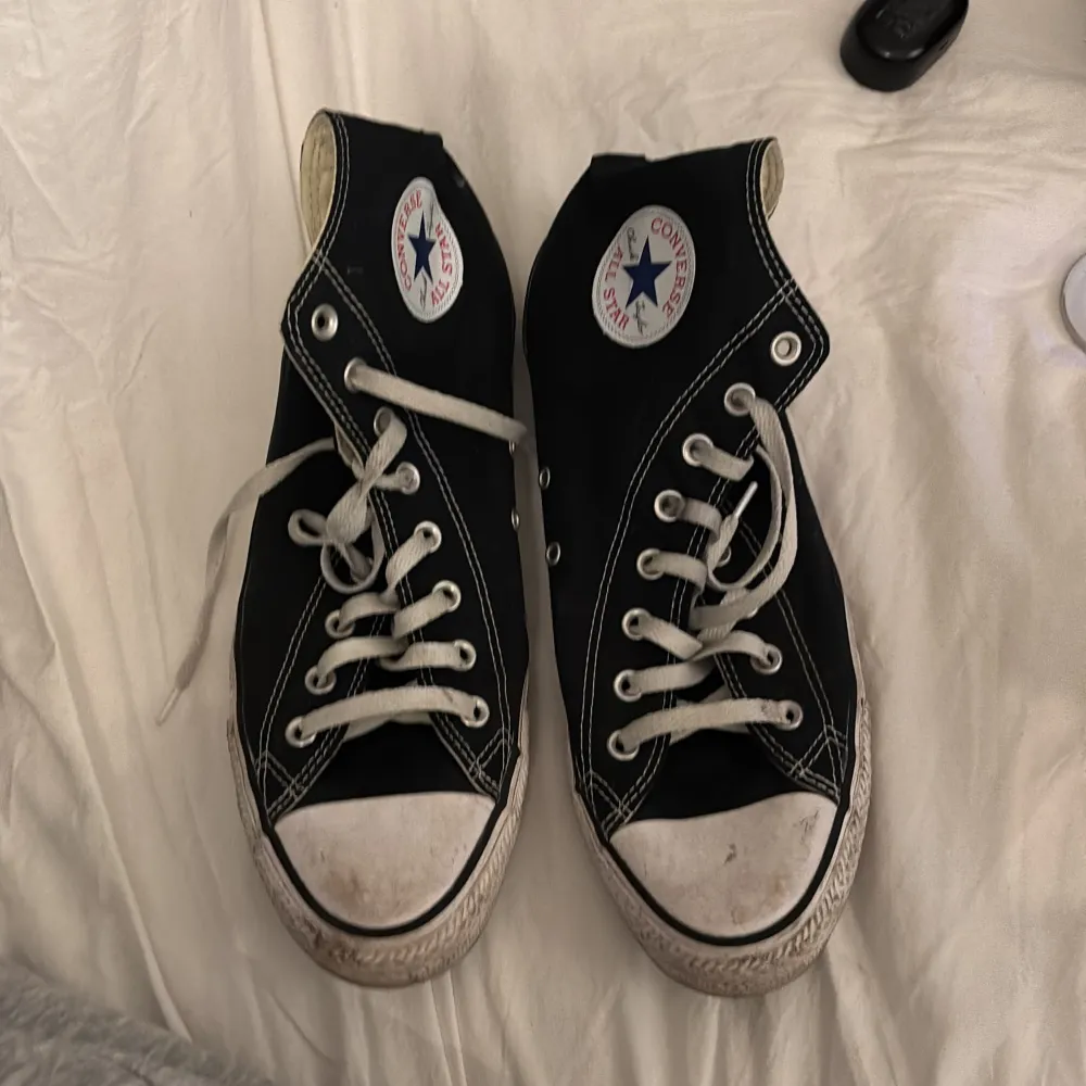 Säljer ett par klassiska svarta Converse All Star sneakers i bra skick. De har den ikoniska vita sulan och snörning, med det välkända logotypmärket på sidan. Perfekta för vardagsbruk och ger en cool, avslappnad stil.. Skor.