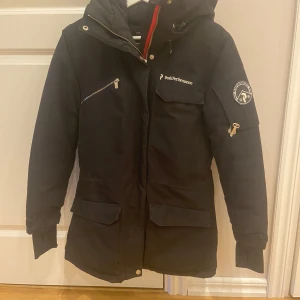 Svart vinterjacka från Peak Performance - Säljer en Peak Performance Jacka stl XS men passar  även stl S  Jackan är varm och perfekt för vintern!   Lite märken finns vid krage , syns mer på bild än på  riktigt.  (bifogar bild 4)   Sparsamt använd