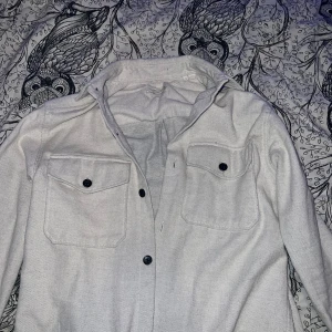 Vit overshirt från Jack & Jones - Säljer en stilren vit overshirt från Jack & Jones i storlek S. Skjortan har långa ärmar och två bröstfickor med knappar. Perfekt för både vardag och fest! 🕺knappt använd, nästan helt ny. Buda tack!