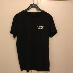 Säljer en svart t-shirt från Vans i bra skick. Den har en klassisk passform med korta ärmar och en vit Vans-logga på bröstet. Perfekt för vardagsbruk eller en avslappnad stil. Passar till det mesta och är superbekväm!