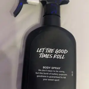 En svart sprayflaska med texten 'Let The Good Times Roll'. Den innehåller en kroppsspray med doft av smörig popcorn. Flaskan har en praktisk spraypump och är designad för att ge en söt och unik doftupplevelse. Köpte den för den gick viral men va inte riktigt nått för mig den är fortfarande ny. Köpt för 365kr