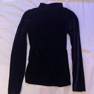 Svart polo med sammetskänsla  - En svart polo från märket "first class party" med en len sammetskänsla. Endast använd väldigt få gånger och utan defekter. Perfekt till nyår eller andra festliga sammanhang!🥂