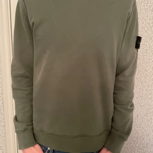 Stone Island Sweatshirt - Jag säljer en olivgrön stone island tröja i fint skick. Tröjan köptes på Nk. 100% äkta!    Modell: 180 cm men passar även kortare personer.  Storlek: S                                             Hör av dig vid minsta fundering!  💯🫒