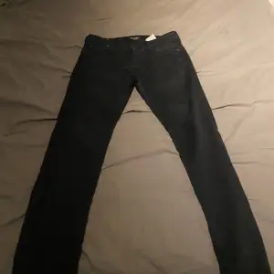 Säljer ett par svarta slim jeans från Superdry i storlek 32. De är i bra skick och perfekta för både vardag och fest. Jeansen har en klassisk design med knappgylf och fem fickor. Passar perfekt till en avslappnad stil eller en mer uppklädd look.