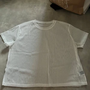 Vit randig topp från Shein - Säljer en vit randig topp från Shein i storlek L. Toppen har en luftig och lätt design med korta ärmar. Gjord i syntet. Passar både till vardags och festliga tillfällen!