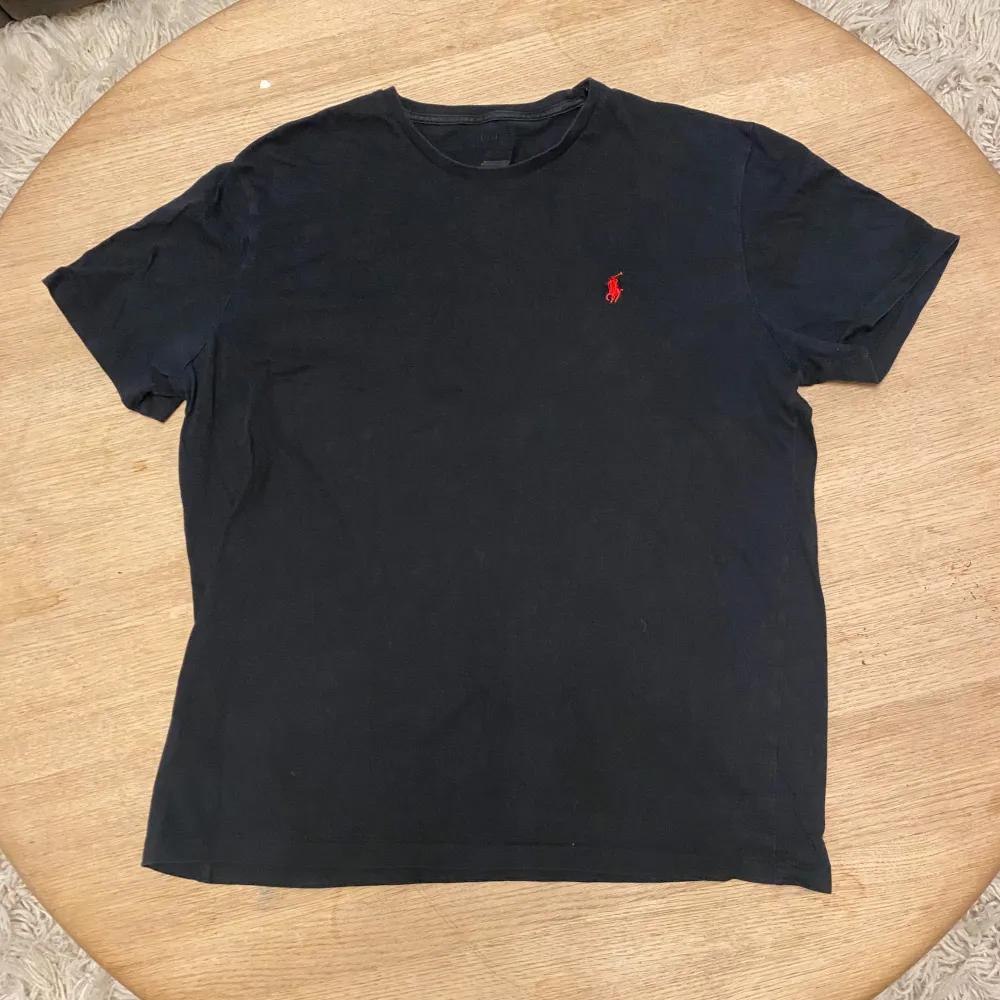 Säljer en svart t-shirt från Polo Ralph Lauren i storlek M. 9,5/10 skick som ny. Kvitto och box ingår ej vilket är anledningen till att jag säljer den billigt. Priset ska inte sänkas mycket men går att diskuteras vid en snabb affär. Kom gärna med prisförslag och frågor!. T-shirts.