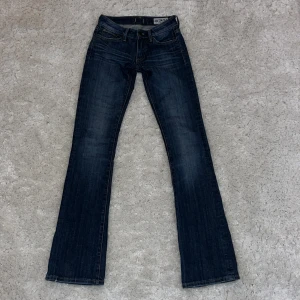 Low waist bootcut jeans  - Säljer mina skitsnygga mörkblå lågmidjade bootcut jeans från Crocker i storlek 24/34. De är i mycket bra skick och endast använda ett fåtal gånger då de är försmå för mig. Midjemåttet är 35 cm rak över och innerbenslängden är 88 cm. Men jag som är 162 cm tycker längden var bra då de la sig snyggt vid fötterna även om du är kortare. På sista bilden ser du även att de e väldigt snygga detaljer på färgen i jeansen. Det är bara fråga om ni har några funderingar❤️