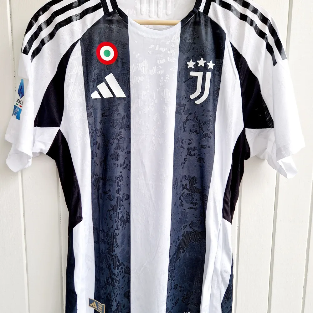 Säljer en Juventus-matchtröja för årets säsong 2024/25 med Vlahović på ryggen. Tröjan är en reprint i nyskick med emblem och patchar av högsta kvalité. Aldrig använd. Player version, bättre kvalité än en vanlig matchtröja.   Notera: Tröjan är tajt i passformen. Mostvarar mer medium än large.. Sportswear.