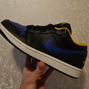 Nike Air Jordans i svart och blått - Säljer ett par Nike Air Jordans i svart och blått med gula detaljer. Skorna är i nytt skick och kommer i originalkartong. Perfekta för både vardag och fest med sin snygga design och bekväma passform. Storlek och mer info finns vid intresse!