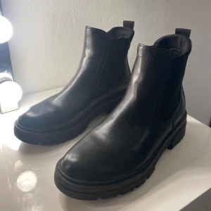 chelsea boots - Snygga svarta korta boots i skinn med elastiska paneler på sidorna för enkel på- och avtagning. Perfekta för både vardag och fest, med en robust sula som ger bra grepp. Dem är från So All, köpta på din sko. De är i mycket bra skick och passar perfekt till höst- och vinteroutfits. kom privat för fler bilder och mer info!