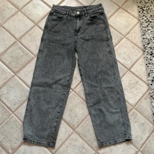 Grå baggy jeans från H&M - Säljer ett par grå baggy jeans från H&M i storlek 152. De har en justerbar midja för perfekt passform. Perfekta för en avslappnad stil och passar till de flesta tillfällen. Skicket är mycket bra och de är superbekväma att ha på sig. Perfekta för höst och vår!