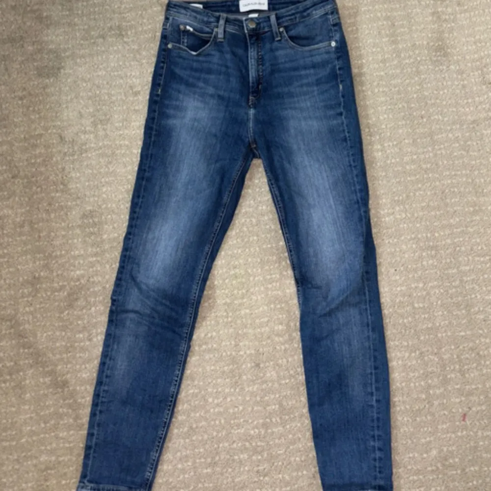 Säljer ett par snygga blå jeans från Calvin Klein i storlek W30. De har en klassisk straight fit och är i mycket bra skick. Perfekta för både vardag och fest! 👖✨. Farkut & Housut.