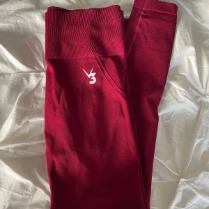 Träningstights från V3 Apparel - Säljer ett par vinröda seamless leggings från V3 Apparel i storlek S. 