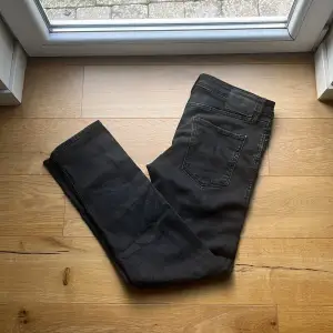 Säljer ett par svarta jeans från Jack & Jones i storlek 30/32. De har en bekväm passform och är perfekta för både vardag och fest. Jeansen är i bra skick och har en klassisk design med fem fickor och knappgylf. Perfekta för höst och vinter! Mvh ItsForFits 🌟