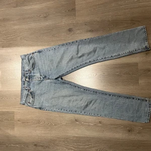 Ljusblå jeans från Zara - Säljer ett par ljusblå jeans från Zara i storlek 42 (32,32). De har en klassisk straight fit och är perfekta för vardagsbruk. Jeansen är i bra skick och har en snygg, enkel design med fem fickor och knappgylf. Perfekta för både vår och höst!