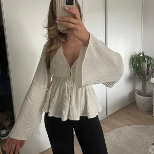 Ribbad vit blus - Vågigt ribbad vit blus. Perfekt till middagar och liknande event. Aldrig använd så den är i nyskick.