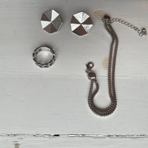 Smycken - Säljer dessa smycken då de aldrig använts. Ringen är i något sorts flätat mönster. Örhängen: 40kr Armband:25kr Ring:20kr Allt tillsammans 70kr