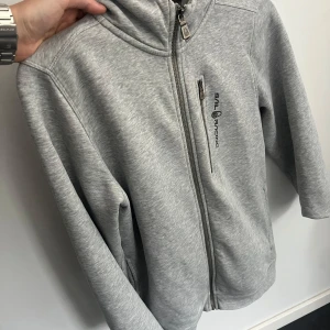 Sail racing hoodie  - Säljer denna gråa sail racing hoodie i bra skick. Den är i storlek 176 men passar även XS. Vid fler frågor hör gärna av dig.