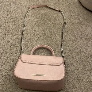 En rosa väska - Är jätte fin rosa väska från något ställe i polen. Lite sönder på framsidan på kanten inget man tänker på. Använd några fåtal gånger.
