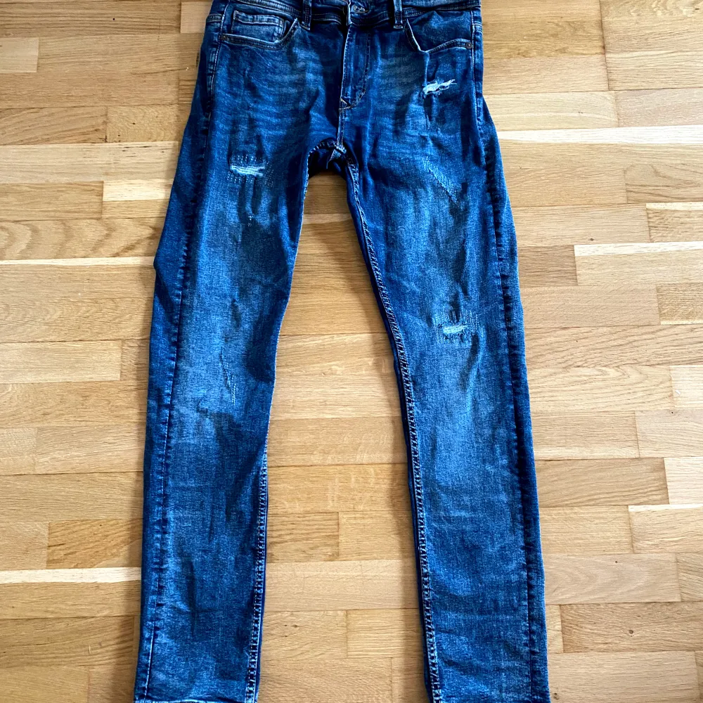 Säljer ett par snygga blå jeans från Snog/Denim. De har en klassisk femficksdesign och en cool, sliten look med diskreta slitningar. Perfekta för en avslappnad stil! 🕶️. Jeans & Byxor.