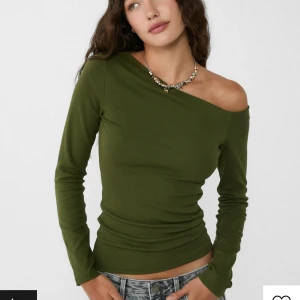 Offshoulder tröja - Grön asymmetrisk tröja från stradivarius. Första bilden lånad. Den har bara änvänts en gång och säljs pga att den är för liten. 