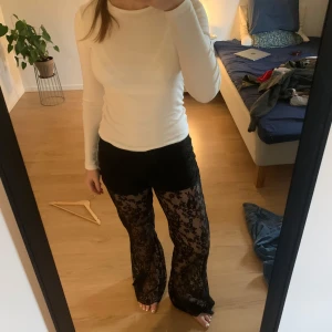 Spetsbyxor från NA-KD - Säljer ett par supersnygga utsvängda spetsbyxor från NAKD. Köptes här på Plick i nyskick och har enbart använts 1 gång. Passar perfekt till fest.